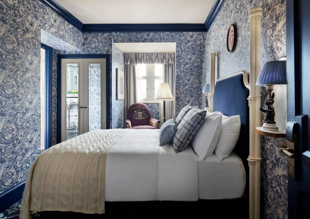 Bedroom with blue wallpaper and a large bed at The Randolph Hotel Oxford