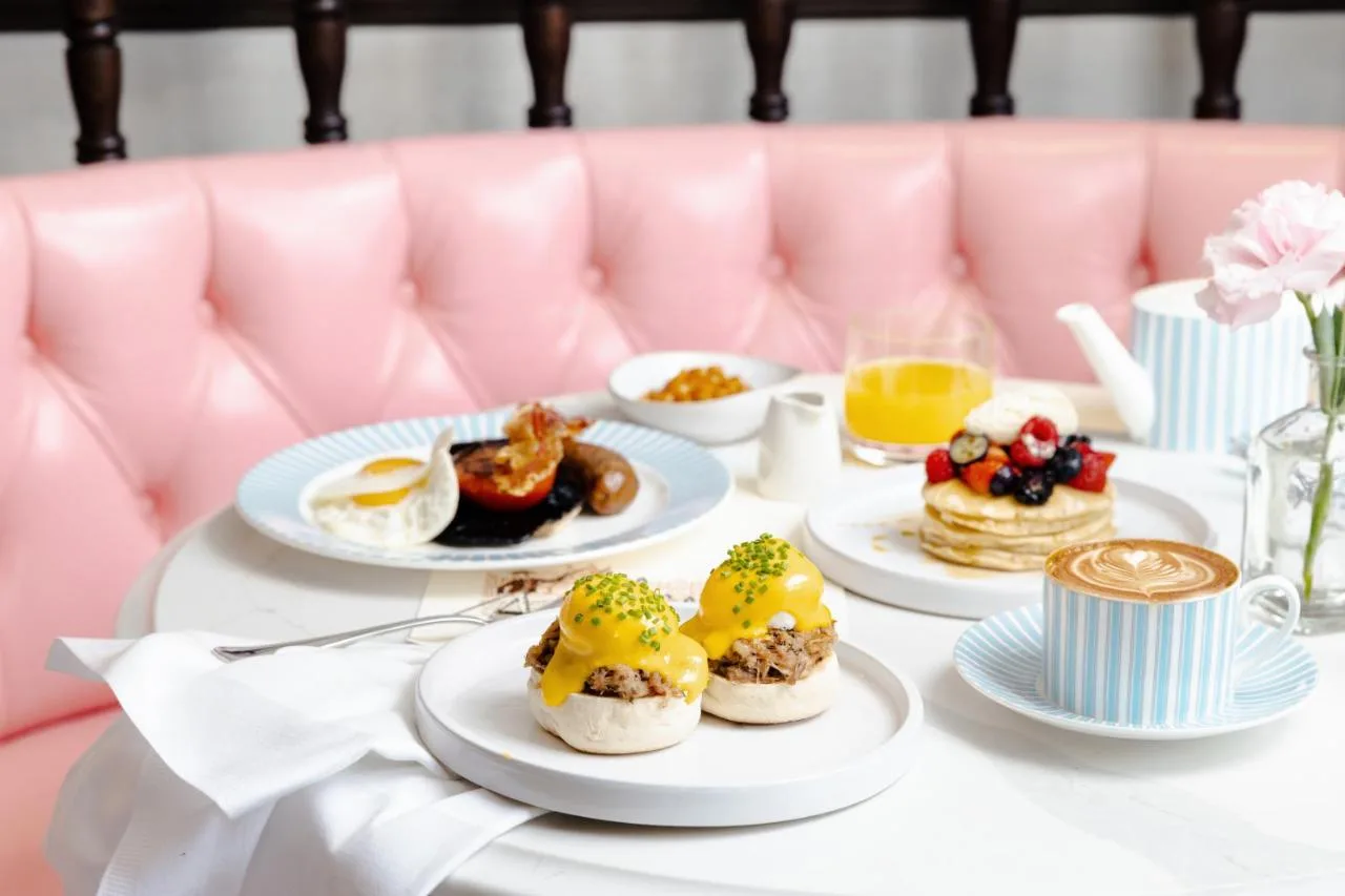 Plates of food on a pink couch at The Randolph Hotel Oxford